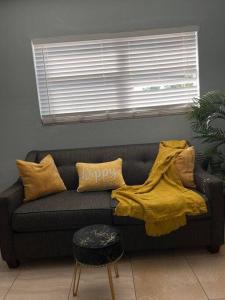 a living room with a couch with a yellow blanket at The Citrus Guesthouse in Tampa in Tampa