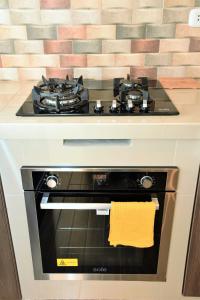 a stove top oven with a yellow towel on it at Apartamento Hermoso en Residencial - Huacachina in Ica