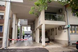 a building with a car parked outside of it at Mac Aviator City Center Two Double Bed Apartment in Niš