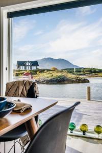 a room with a table and chairs and a large window at Rorsundet Brygge in Vega