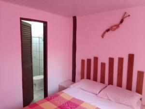 1 dormitorio con paredes rosas y 1 cama con salto en Pousada A Vila do Pirata en Prado