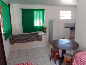 a small room with a bed and a table at Pousada A Vila do Pirata in Prado