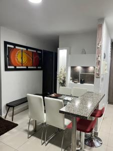 comedor y sala de estar con mesa y sillas en APARTAMENTO CONDINA PEREIRA en Pereira