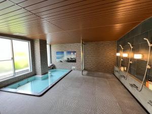 a large bathroom with a swimming pool in it at Kitashiga Holiday Inn in Yamanouchi