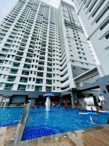a swimming pool in front of a large building at Attractive 3 Bedroom Condo with Pool-D Raudhah Homestay in Kajang
