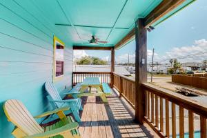 a porch with two chairs and a picnic table at Down By The Sea in Port Aransas