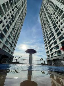 a person with an umbrella in between two buildings at Attractive 3 Bedroom Condo with Pool-D Raudhah Homestay in Kajang