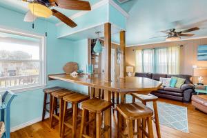 a kitchen with a bar with stools and a living room at Down By The Sea in Port Aransas