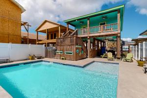 a house with a swimming pool and a house at Down By The Sea in Port Aransas