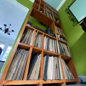 a book shelf filled with records at Hostal Cumbres del Volcan Flor Blanca in San Salvador