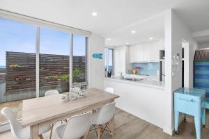 a kitchen and dining room with a table and chairs at Point Grey Apartment 2 in Lorne