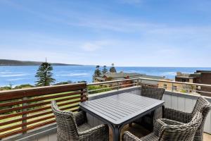 a table and chairs on a balcony with the ocean at Point Grey Apartment 2 in Lorne