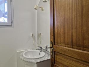 La salle de bains est pourvue d'un lavabo et d'une porte en bois. dans l'établissement Cottage, Hillion, à Hillion