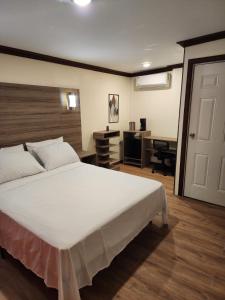 a bedroom with a large white bed and a desk at Pit Stop Hostel in Aguada