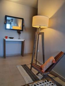 a lamp and a chair in a room with a mirror at Marfil in Posadas