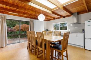 een keuken en eetkamer met een houten tafel en stoelen bij Garden House in Opotiki