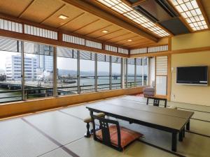 a large room with a table and large windows at Ohashikan in Matsue