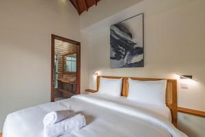 een slaapkamer met een groot wit bed en handdoeken bij 5 BR Villa Sultan Luxury Entertainment and Relaxation in Seminyak
