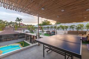 an outdoor patio with a ping pong table and a pool at 5 BR Villa Sultan Luxury Entertainment and Relaxation in Seminyak
