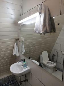 a white bathroom with a sink and a toilet at Porsu in Canacona