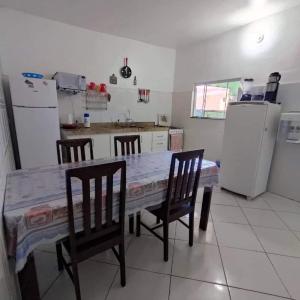 a kitchen with a table and chairs and a refrigerator at Space Hostel , quartos privativos in Arraial do Cabo