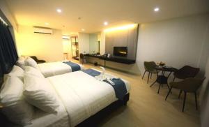 um grande quarto de hotel com duas camas e uma mesa em The First Islatel em Lucap