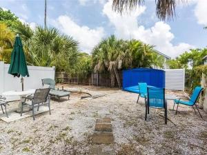 a patio with chairs and a table and a umbrella at Charming Studio Unit Across from Lido Key Beach in Sarasota