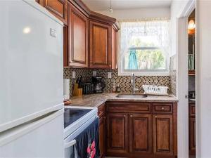 萨拉索塔Charming Studio Unit Across from Lido Key Beach的厨房配有木质橱柜、水槽和窗户
