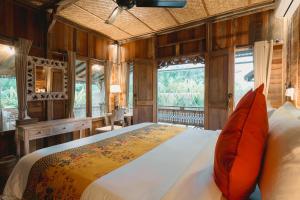 Nauna Villa Ubud في أوبود: غرفة نوم بسرير كبير ومخدات حمراء