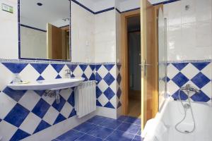 a blue and white bathroom with a sink and a tub at Hotel Azul de Galimar in San Vicente de la Barquera
