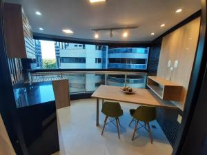 uma pequena cozinha com uma mesa de madeira e cadeiras em Apartamento Estilo Prime em Salvador
