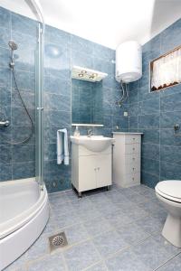 ein Badezimmer mit Dusche, Toilette und Waschbecken in der Unterkunft Apartment Milena in Srima