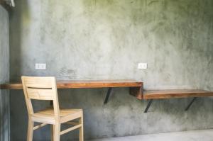 a wooden desk with a chair next to a wall at Pobla Hotel in Oslob