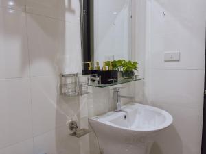 a white bathroom with a toilet and a sink at Tam Coc Viet Ha Homestay in Ninh Binh