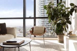 sala de estar con silla y planta en Luxuria Apartments - Fulton Lane, en Melbourne