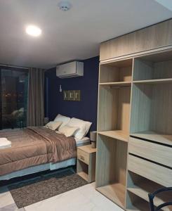 a bedroom with a bed and a room with shelves at Hermoso Departamento completamente equipado in Colonia Mariano Roque Alonso