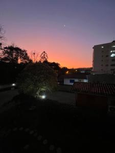 um pôr-do-sol numa cidade com um edifício em Chalés no meu quintal em Lauro Müller