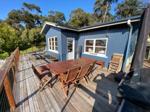 a picnic table and chairs on a deck with a tiny house at Lorne Haven in Lorne