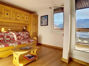 ein Schlafzimmer mit Bett, Tisch und Fenstern in der Unterkunft Appartement cosy aux Menuires · Accès pistes · Parking inclus - FR-1-344-850 in Les Menuires + 9 Fotos