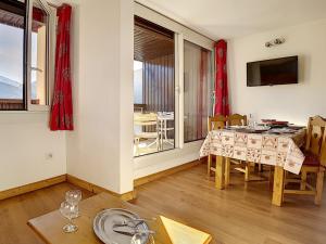ein Esszimmer mit Tisch und Stühlen und einem Fenster in der Unterkunft Appartement cosy aux Menuires · Accès pistes · Parking inclus - FR-1-344-850 in Les Menuires