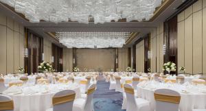 a large banquet hall with white tables and chairs at Pullman Yantai Center in Yantai +80 photos
