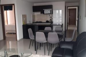 a kitchen with a group of chairs and a table at Elegante departamento en Urbarí - Cond. Aruma in Santa Cruz de la Sierra