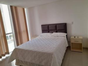 a bedroom with a large bed and a window at Elegante departamento en Urbarí - Cond. Aruma in Santa Cruz de la Sierra