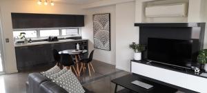 a living room with a couch and a television at Impressive Central Apartment in Warrnambool