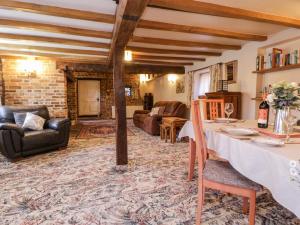 ein Wohnzimmer mit Tisch und Couch in der Unterkunft Brew Cottage in Chislet