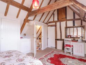 a bedroom with a bed and a table and a mirror at Brew Cottage in Chislet