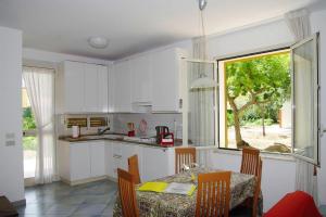 a kitchen with white cabinets and a table and a window at Residence Fontana Barone, Cefalu in Cefalù
