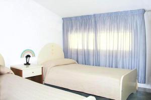 a bedroom with two beds and a window with a rainbow at Residence Fontana Barone, Cefalu in Cefalù