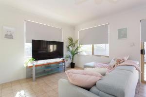 a living room with a couch and a flat screen tv at Living on Lennard - Pet friendly house close to CBD in Perth