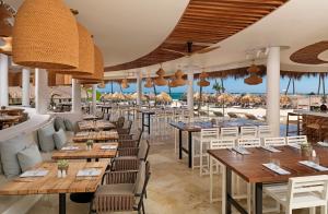 un restaurante en la playa con mesas y sillas en Paradisus Grand Cana, All Suites - Punta Cana -All Inclusive, en Punta Cana